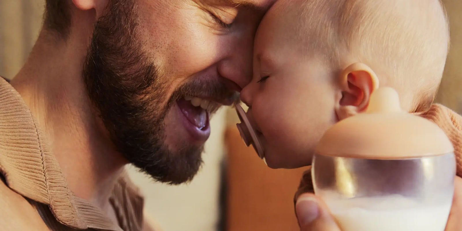 Father Holding Baby Using Emulait Pacifier and Classic Bottle